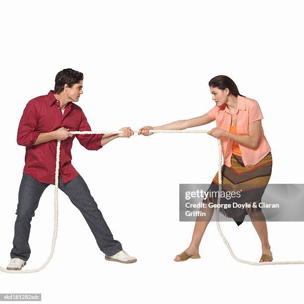 side view of young couple pulling rope - george nader stockfoto's en -beelden