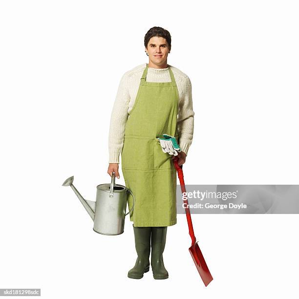 portrait of a man wearing an apron and holding a watering can and shovel - pitorro fotografías e imágenes de stock