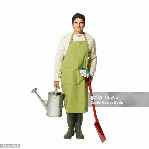 portrait of a man wearing an apron and holding a watering can and shovel - pour spout stock pictures, royalty-free photos & images