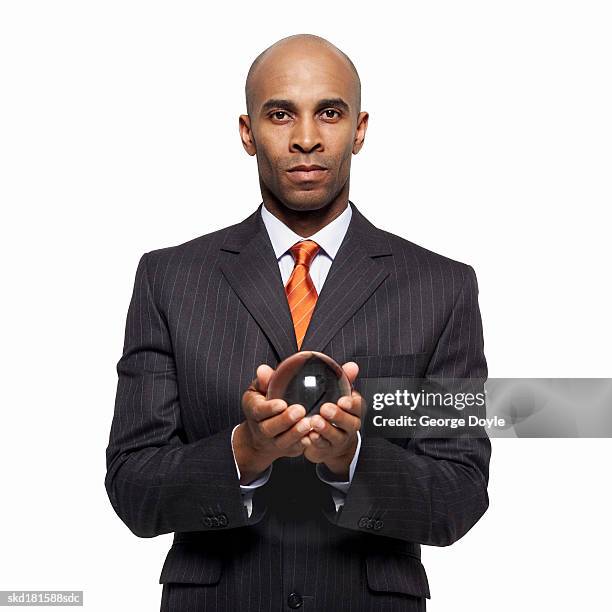 close up of a businessman holding a crystal ball - crystal stock-fotos und bilder