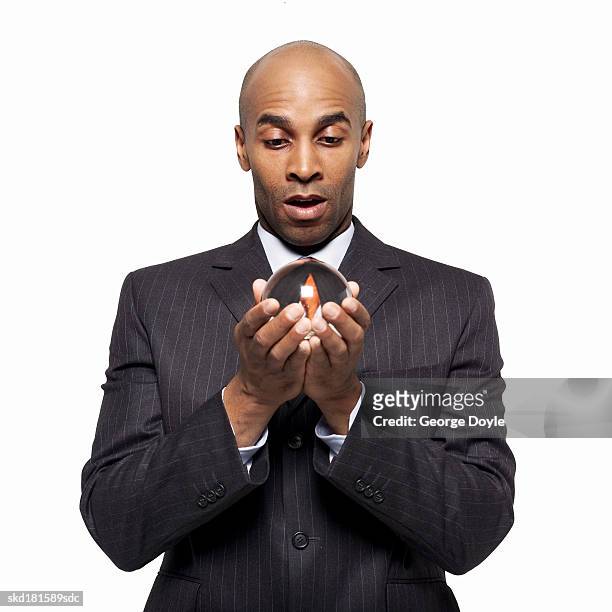 businessman holding a crystal ball - crystal stock-fotos und bilder