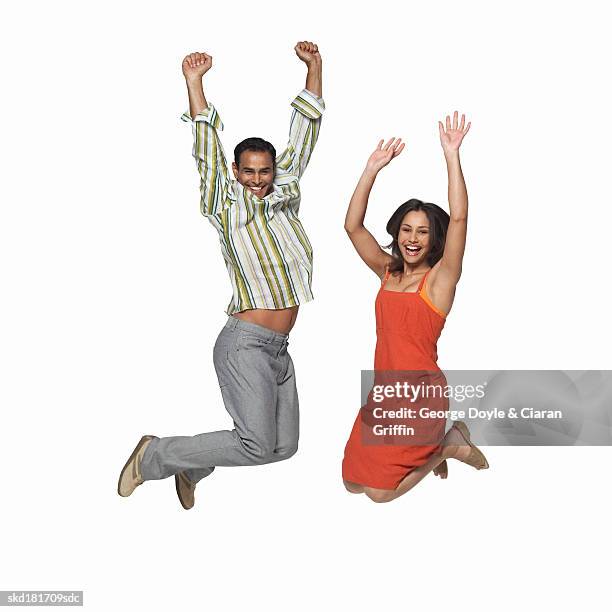 mid adult couple jumping into the air - air date stockfoto's en -beelden