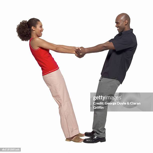 side view of young couple holding hands - george nader stockfoto's en -beelden