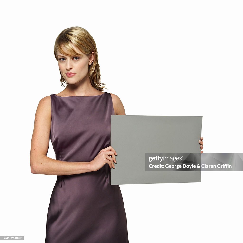 Portrait of young woman holding blank card