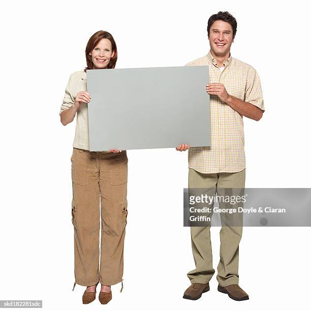 portrait of young couple holding blank card between them - between stock-fotos und bilder