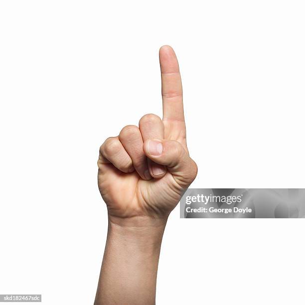 close-up of man's hand holding index finger up - hand opsteken stockfoto's en -beelden