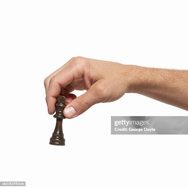 close-up of man's hand holding chess piece - chess piece stock pictures, royalty-free photos & images