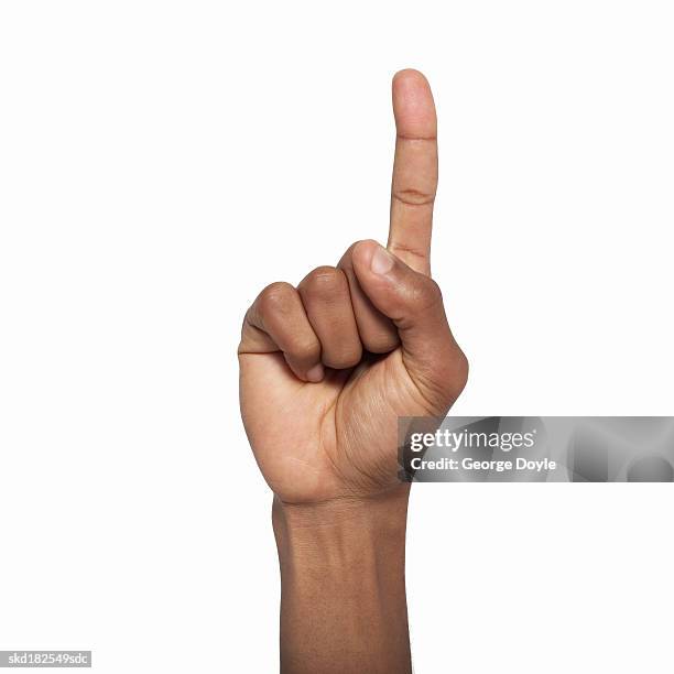 close-up of male hand holding index finger up - hand opsteken stockfoto's en -beelden