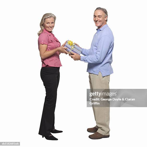 mature couple holding gift between them - between stock-fotos und bilder