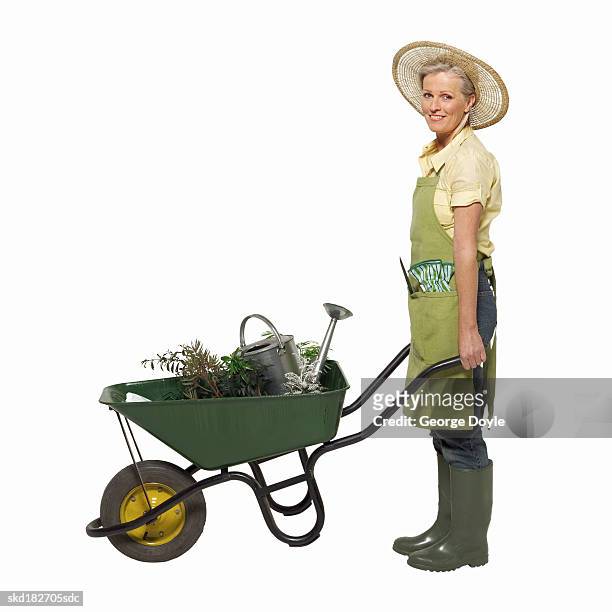 portrait of a woman pushing a wheelbarrow - pour spout stock pictures, royalty-free photos & images