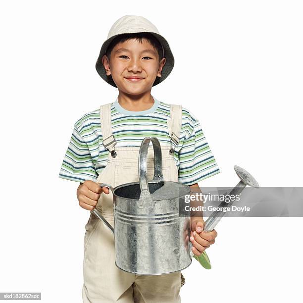 portrait of a girl (8-9) holding a watering can - pitorro fotografías e imágenes de stock