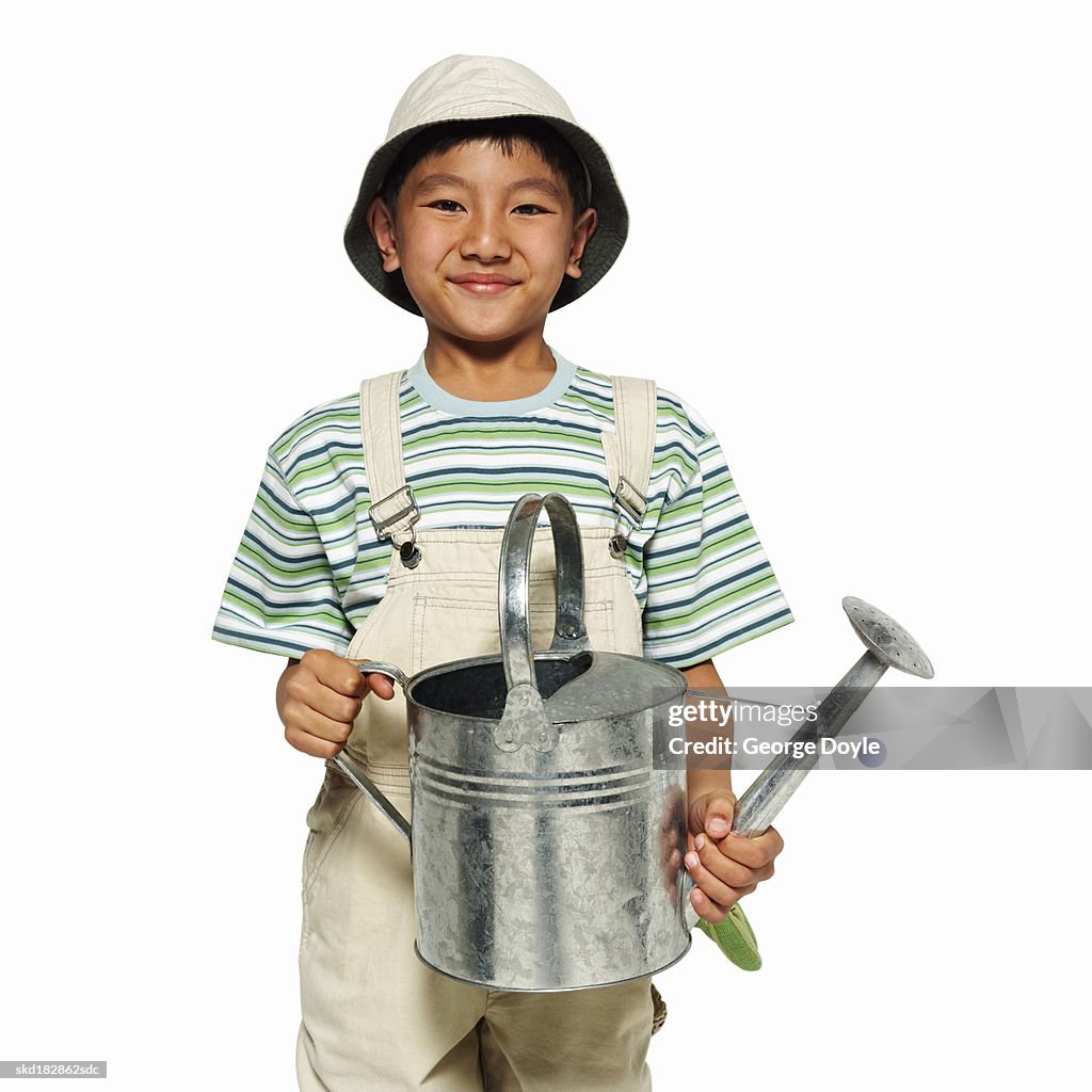 Portrait of a girl (8-9) holding a watering can
