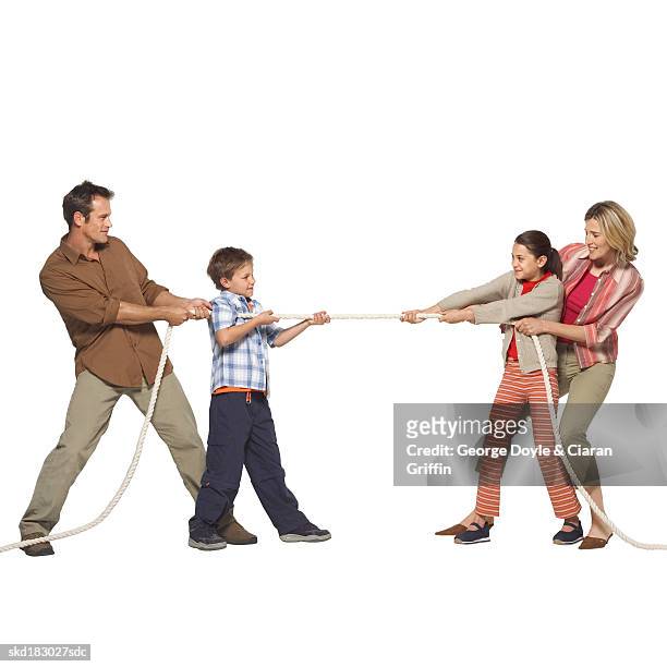 side view of a family playing tug of war - war stock-fotos und bilder
