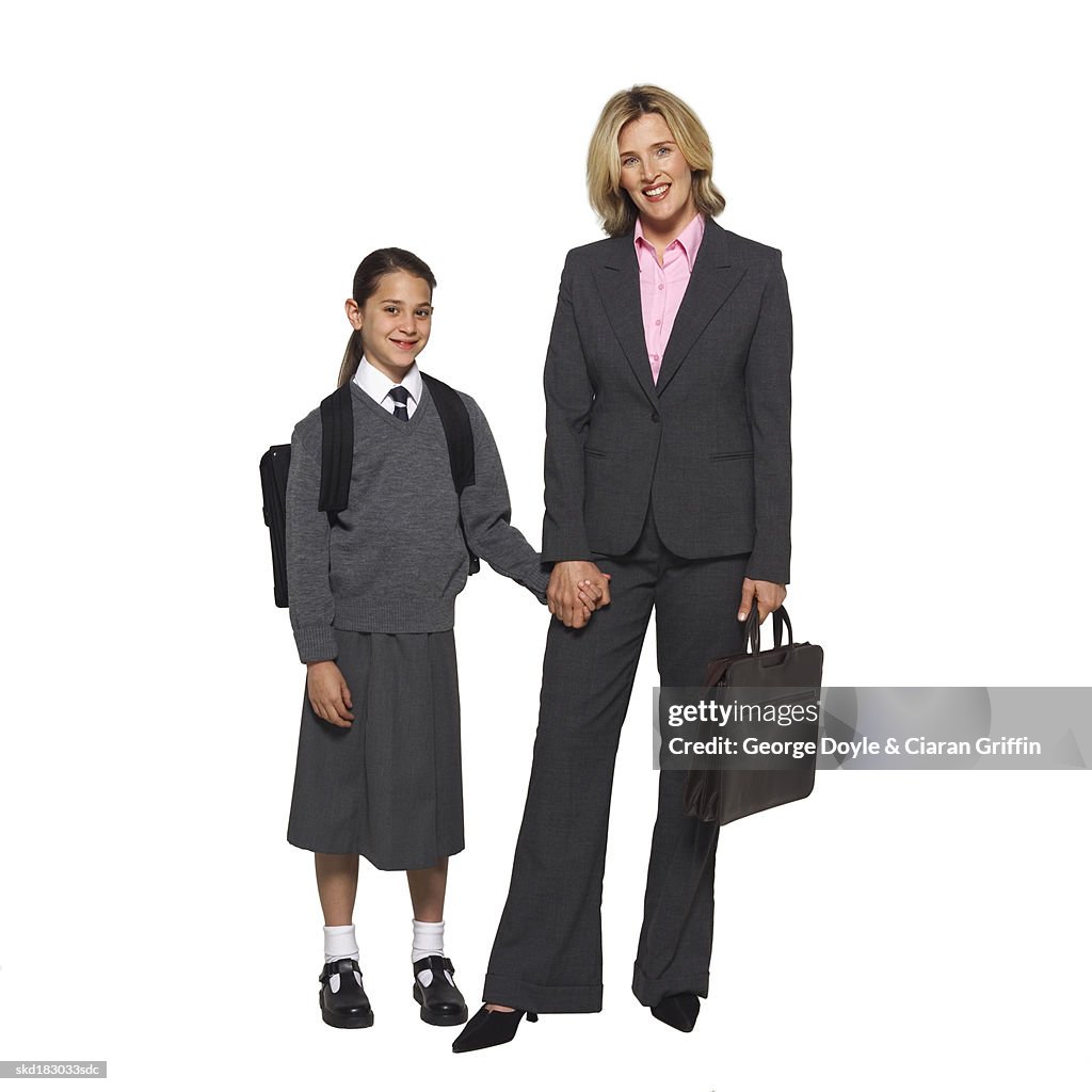 Portrait of a businesswoman holding hands with her daughter (10-11)