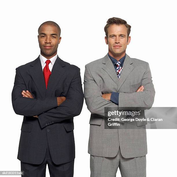 front view portrait of two mid adult businessmen standing with arms crossed - completo da uomo foto e immagini stock