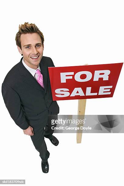 elevated view of a businessman holding a for sale sign - for sale korte frase stockfoto's en -beelden