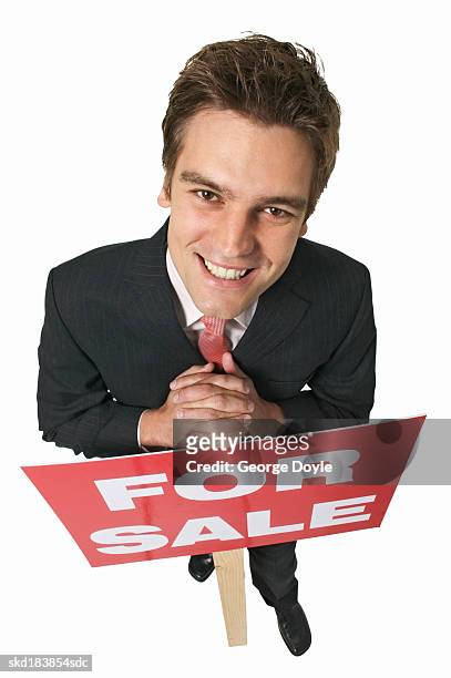elevated view of a businessman holding a for sale sign - for sale korte frase stockfoto's en -beelden