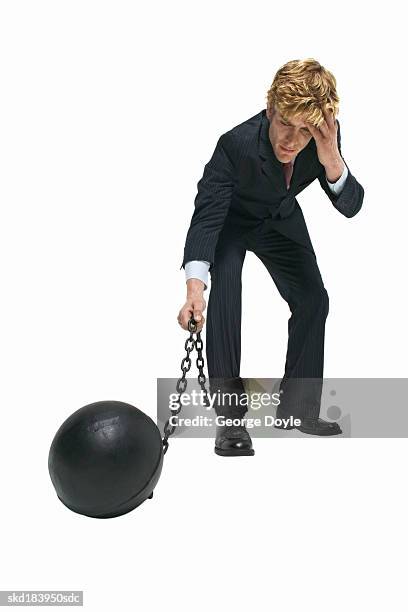 elevated view of a businessman attached to a ball and chain - george nader stockfoto's en -beelden