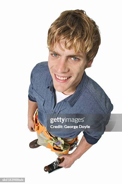 man standing with his hands on his hips wearing a tool belt around his hips - belt stockfoto's en -beelden