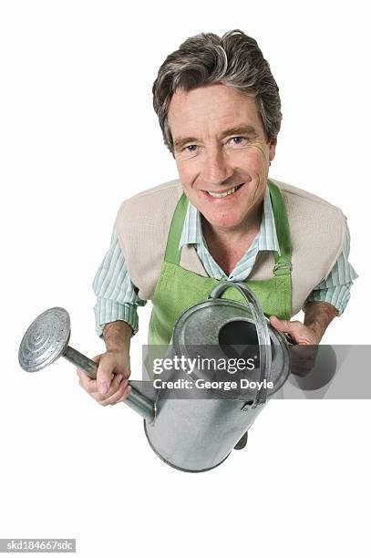 elevated view of a man holding a watering can - pour spout stock pictures, royalty-free photos & images