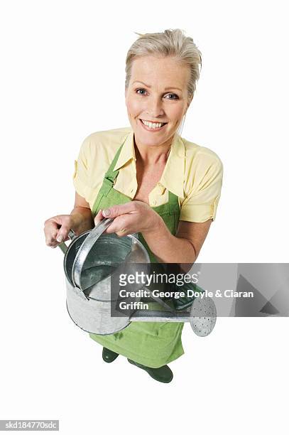 portrait of woman wearing apron and holding watering can - pour spout stock pictures, royalty-free photos & images