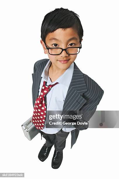 elevated view of a boy (10-11) dressed as a businessman and holding a briefcase - nachahmung erwachsener stock-fotos und bilder