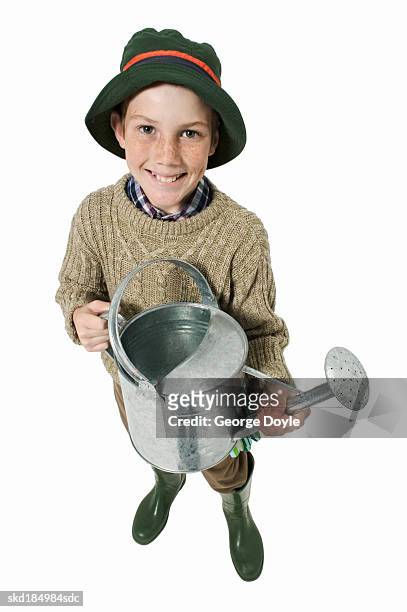 elevated view of a boy (12-13) holding watering can - pitorro fotografías e imágenes de stock