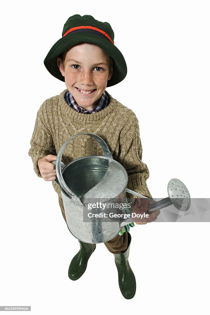 Elevated view of a boy (12-13) holding watering can