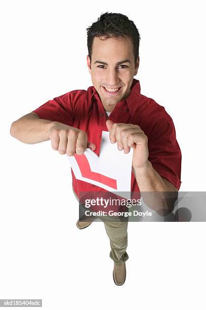 elevated view of a man tearing a driving l-plate - passer ストックフォトと画像