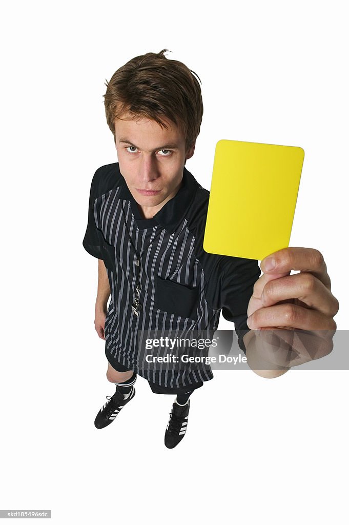 Elevated view of a referee raising his hand with a yellow card