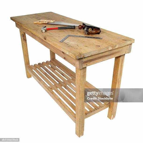 close up of a table with a hammer and saw and plane and t-square on it - établi photos et images de collection