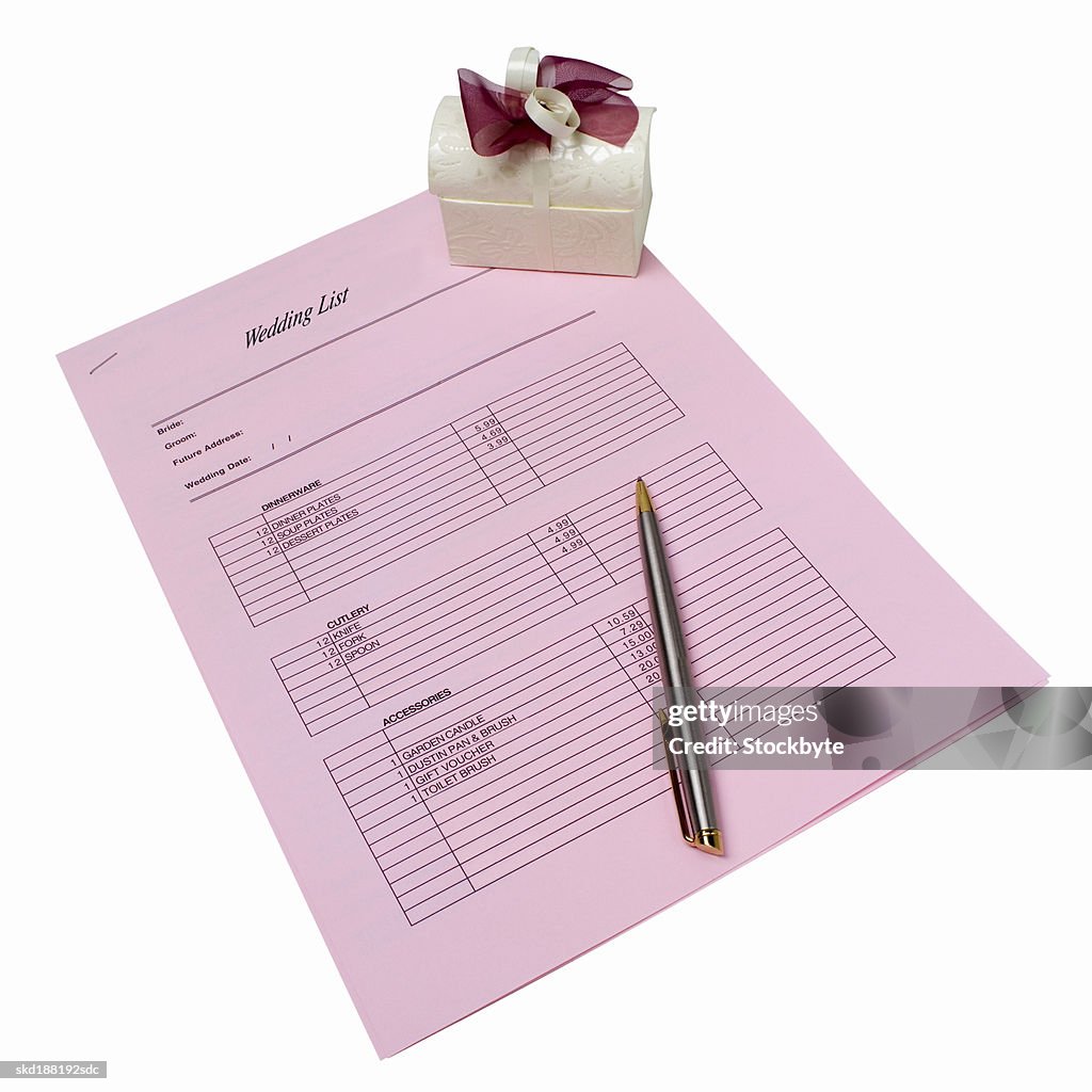 Elevated view of a wedding list and a pen and a gift