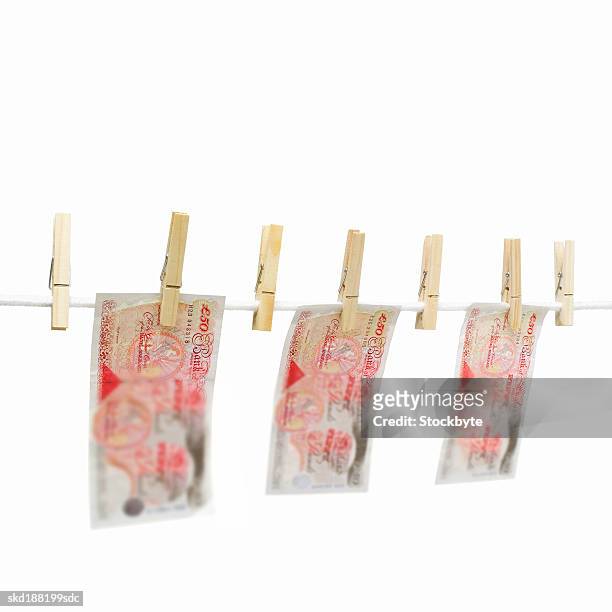 close up of a clothesline with pound notes hanging on with clothes pegs - money laundery stock pictures, royalty-free photos & images