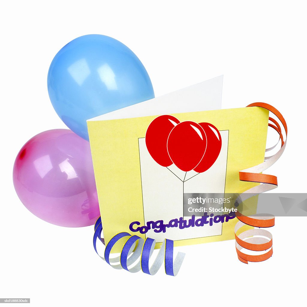 Close-up of a congratulations card and balloons attached to streamers