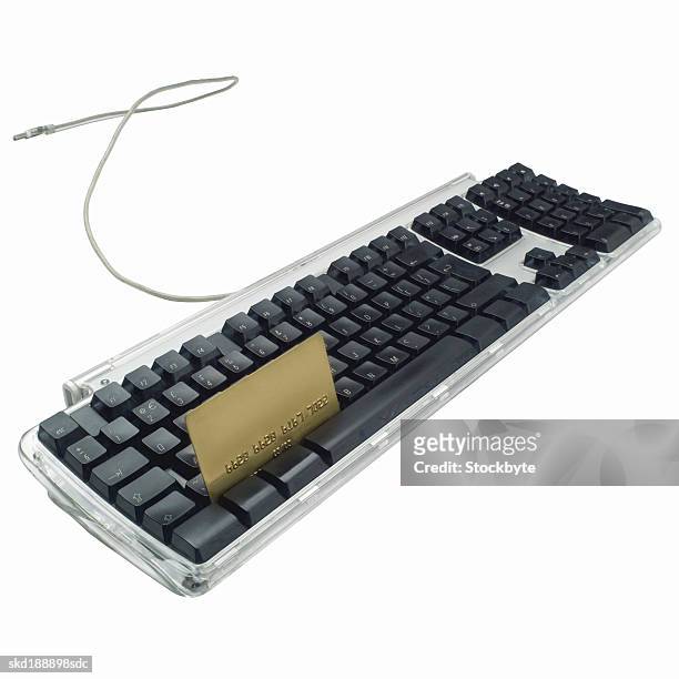 close-up of a computer keyboard and a credit card in between the keyboard buttons - between bildbanksfoton och bilder