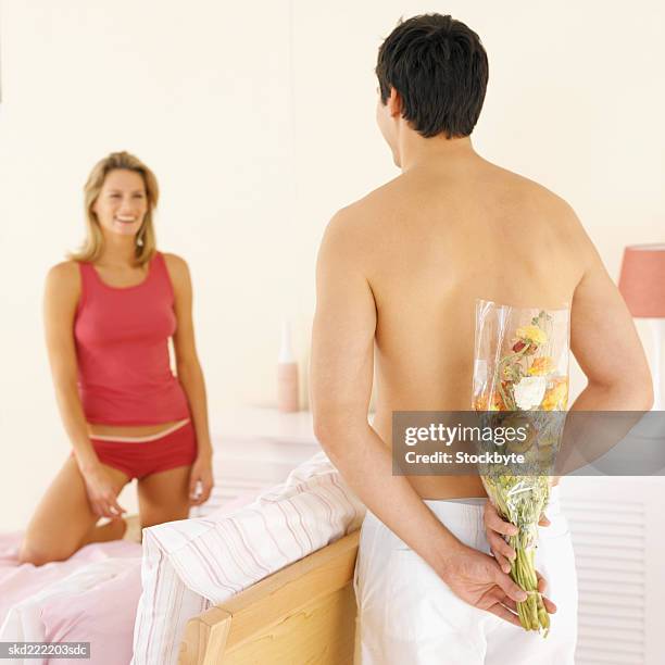 man about to give a woman a bouquet of flowers in the bedroom - about stock pictures, royalty-free photos & images