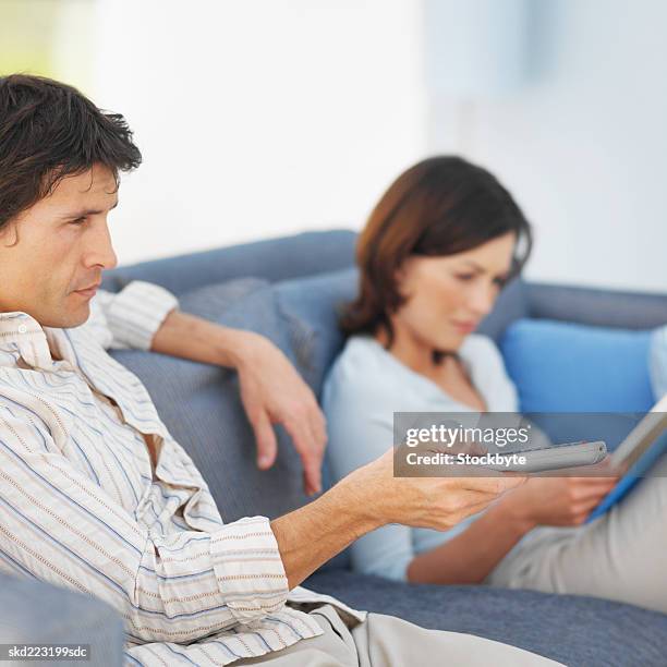 couple relaxing at home - man watching tv foto e immagini stock