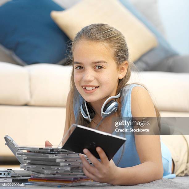 close-up of girl (11-12) looking through collection of cds with headphones around neck - kmart and shop your way celebrate launch of nicki minaj collection stockfoto's en -beelden