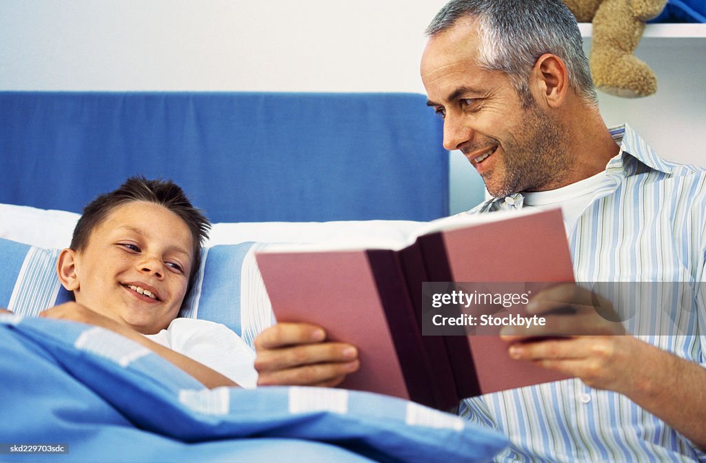 Close-up of father reading story to son (10-11)