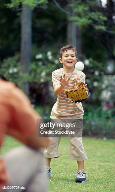 father and son playing baseball in garden (10-11) - catchers mitt stock pictures, royalty-free photos & images