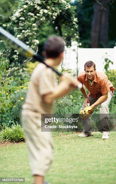 father and son playing baseball in garden (10-11) - catchers mitt stock pictures, royalty-free photos & images