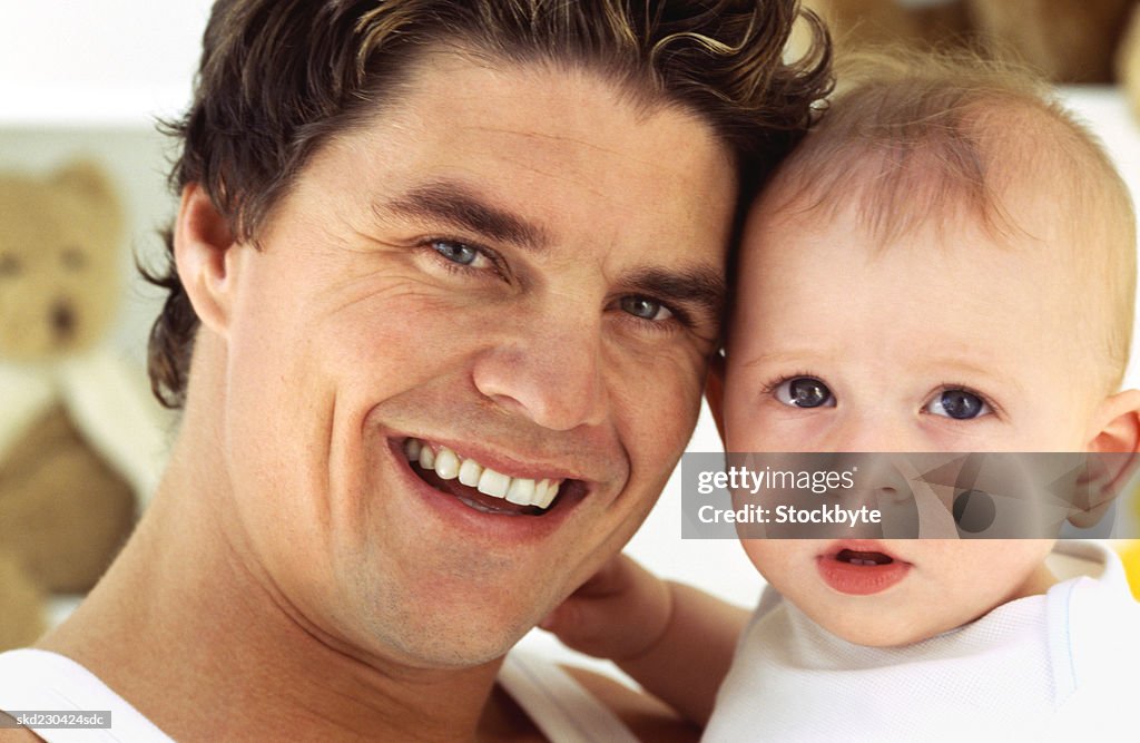 Front view portrait of father holding baby girl (6-12 months)