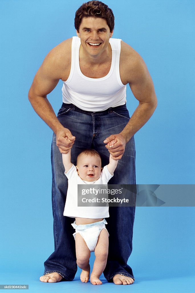 Front view portrait of father holding baby boy (6-12 months)