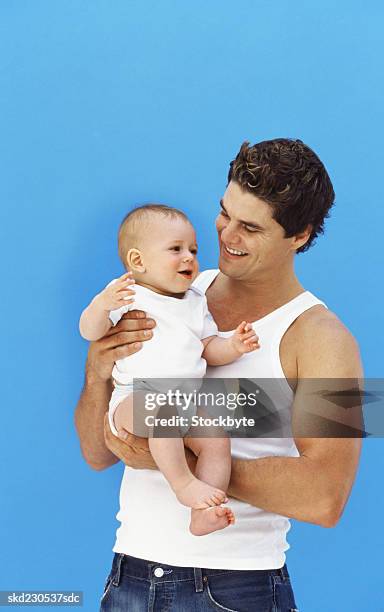 close-up of father holding baby boy (6-12 months) - genderblend stock pictures, royalty-free photos & images