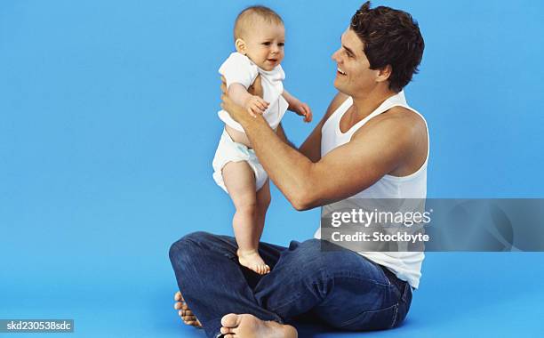 close-up of father holding baby boy (6-12 months) - genderblend stock-fotos und bilder