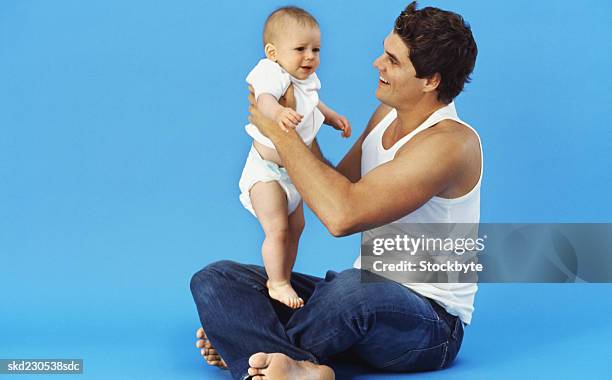 close-up of father holding baby boy (6-12 months) - intergénero fotografías e imágenes de stock