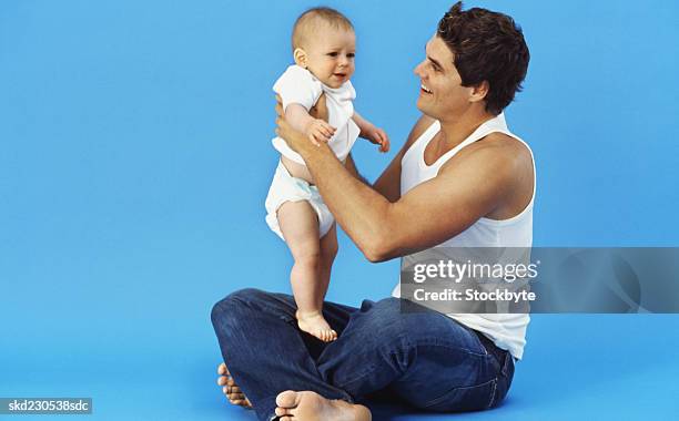 close-up of father holding baby boy (6-12 months) - genderblend stock pictures, royalty-free photos & images