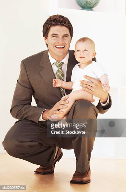front view portrait of father holding baby girl (6-12 months) - intergénero fotografías e imágenes de stock