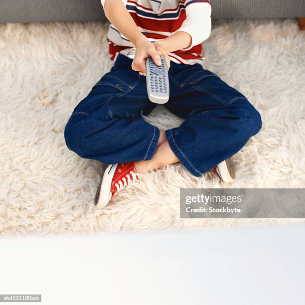 elevated low section view of boy holding remote control - control photos et images de collection