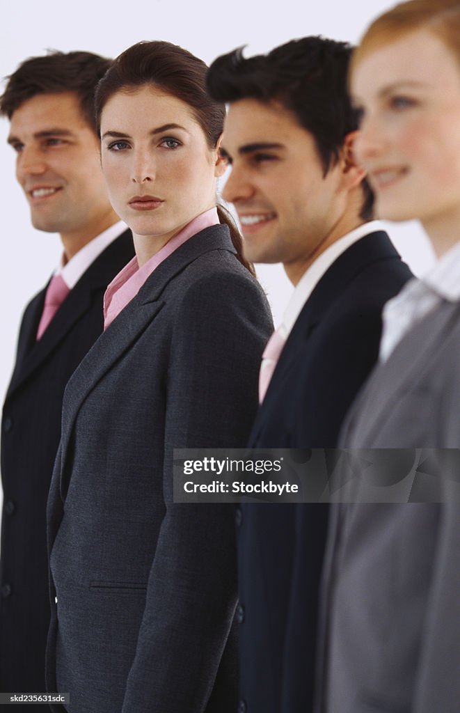 Group of smiling young business executives standing in a row